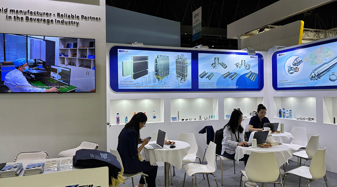 BJY engineering team discussing custom PET preform mold replacement parts with visitors